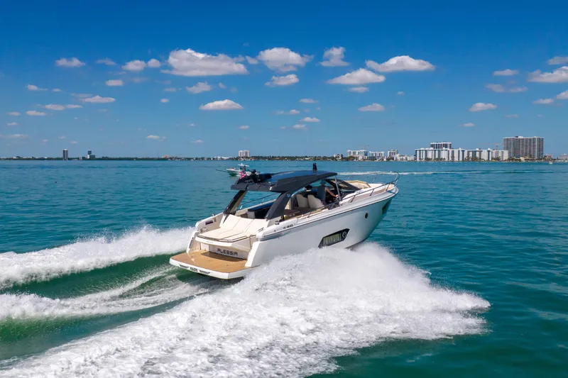 Slide: The Image of 2017 Absolute 40 STL yacht cruising on clear blue waters near a city skyline. - 78