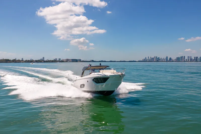 Slide: The Image of Luxury Absolute 40 STL yacht cruising on clear blue waters, city skyline in background. - 80