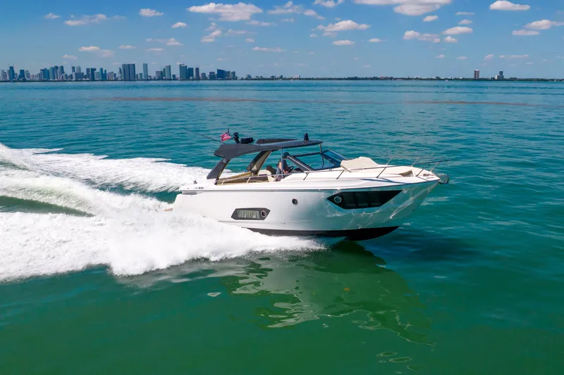 Slide: The Image of 2017 Absolute 40 STL yacht cruising on open water with city skyline in background. - 83