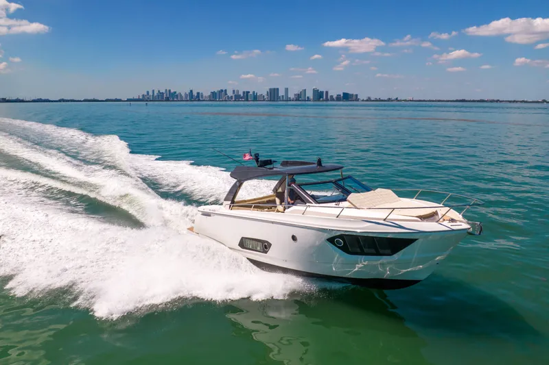 Slide: The Image of 2017 Absolute 40 STL yacht cruising on open water with city skyline in background. - 84