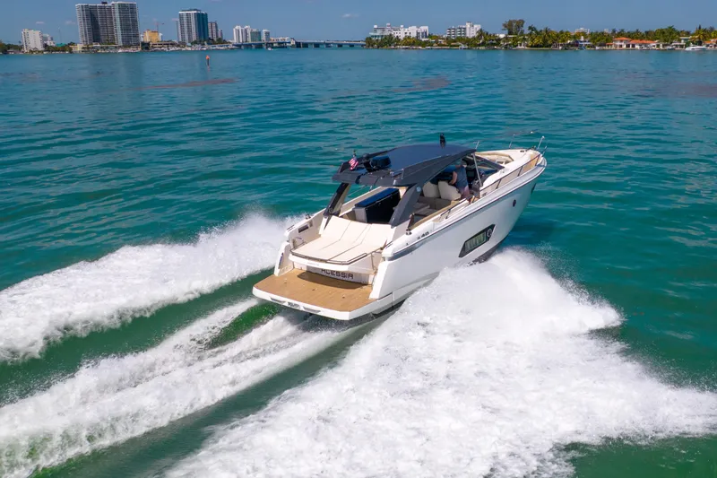 Slide: The Image of 2017 Absolute 40 STL yacht cruising on clear blue water near city skyline. - 87