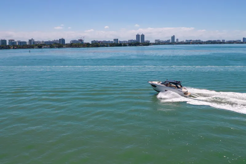 Slide: The Image of 2017 Absolute 40 STL yacht cruising on a sunny day with city skyline backdrop. - 90