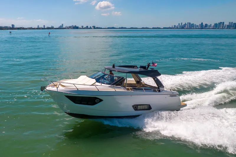 Slide: The Image of 2017 Absolute 40 STL yacht cruising on blue ocean near city skyline. - 93