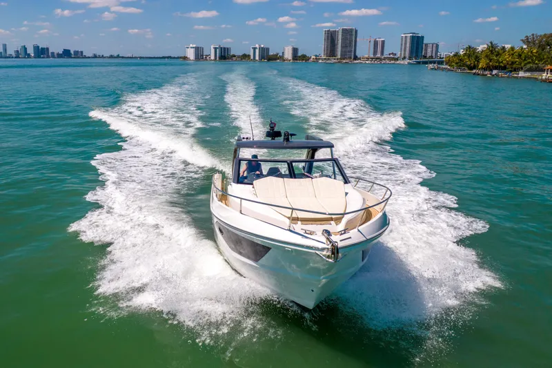 Slide: The Image of 2017 Absolute 40 STL yacht cruising in sunny coastal waters with city skyline. - 95