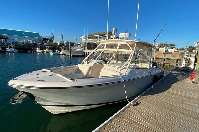 The Image of 2020 Grady-White Freedom 285 boat docked at marina under clear blue sky. - 0