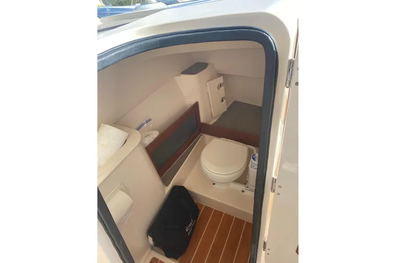 Slide: The Image of Interior of 2020 Grady-White Freedom 285 boat, featuring a compact marine toilet. - 10