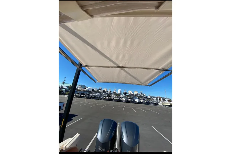 Slide: The Image of 2020 Grady-White Freedom 285 boat with dual engines, parked under a canopy in a marina. - 11