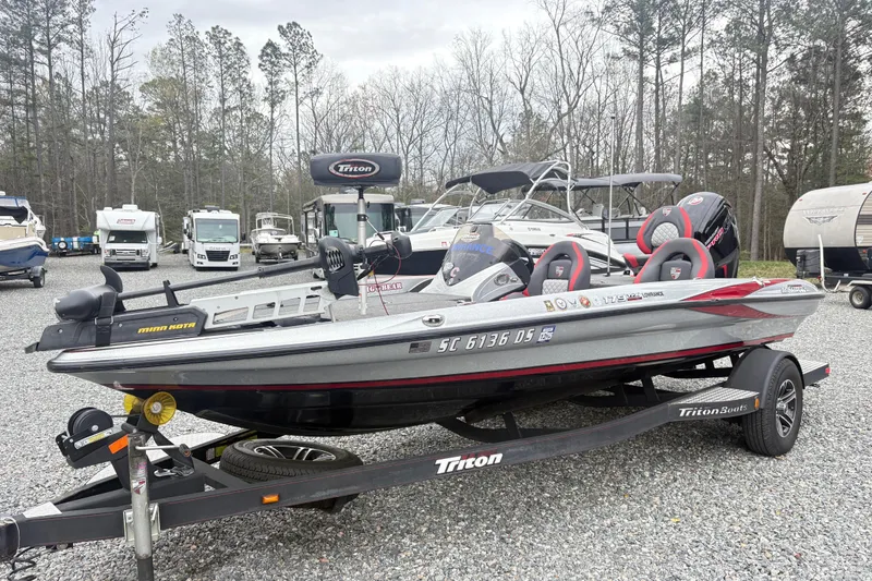 The Image of 2022 Triton 179 TrX boat on trailer in outdoor lot with other vehicles. - 1