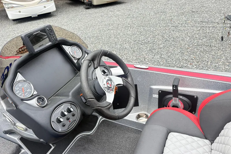 Slide: The Image of 2022 Triton 179 TrX boat dashboard with steering wheel, gauges, and control panel. - 12