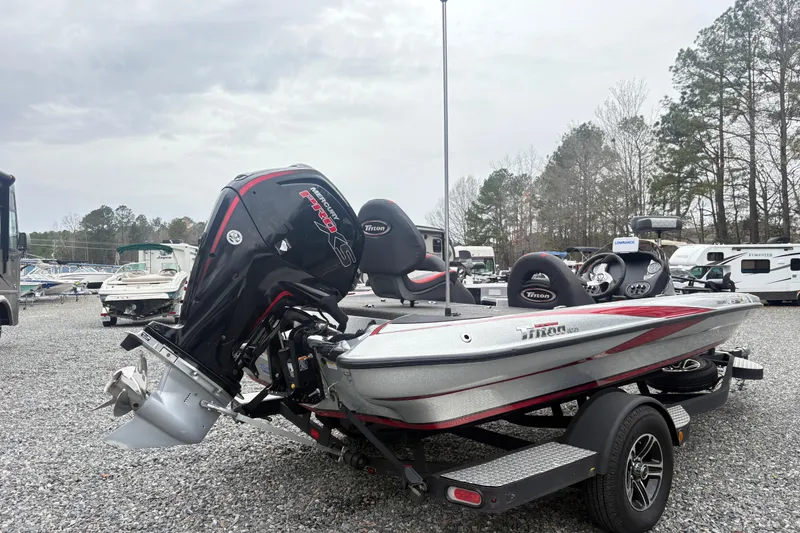 Slide: The Image of 2022 Triton 179 TrX boat with powerful outboard motor in a gravel lot. - 3