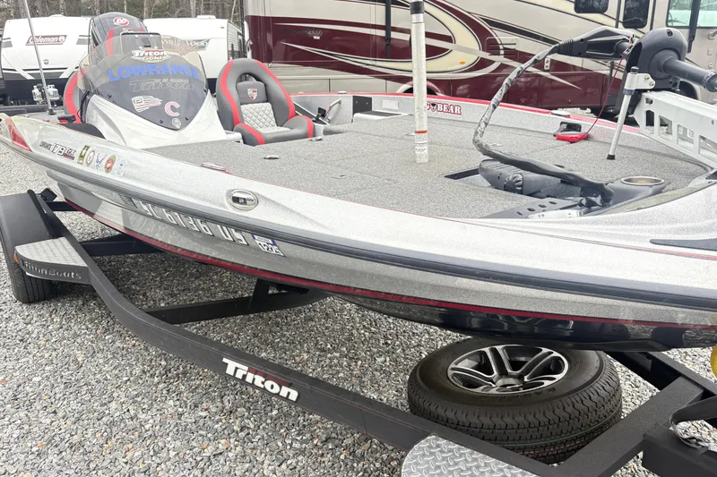 Slide: The Image of 2022 Triton 179 TrX bass boat on trailer, featuring sleek design and modern equipment. - 5