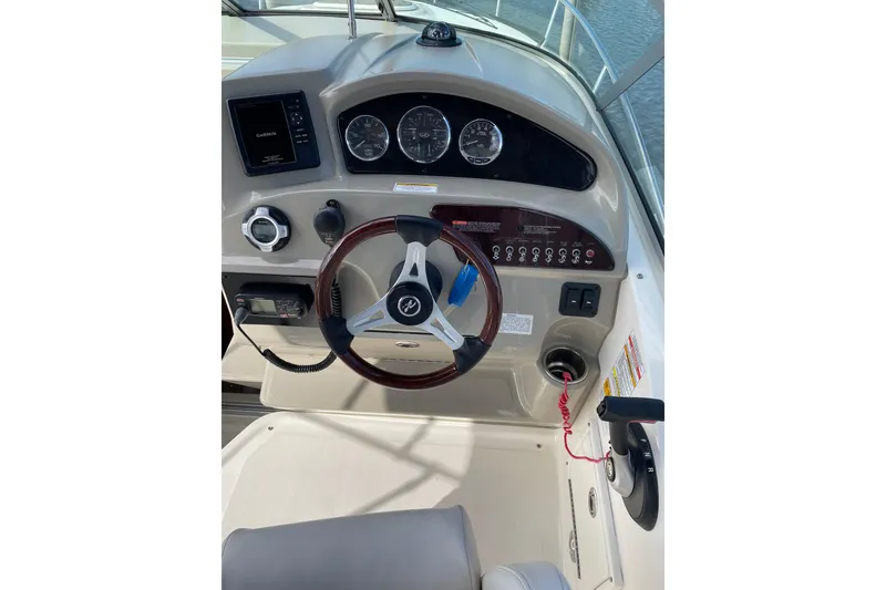 Slide: The Image of Cockpit of 2011 Sea Ray 240 Sundancer with steering wheel and control panel. - 13