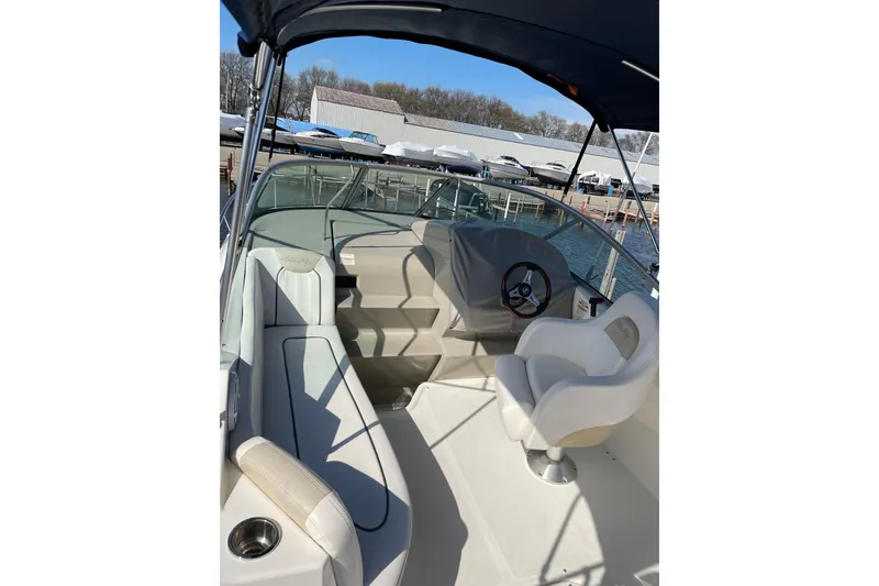 Slide: The Image of 2011 Sea Ray 240 Sundancer boat interior with helm and seating area. - 15