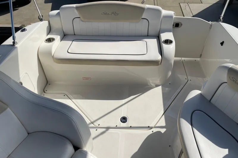 Slide: The Image of Interior view of a 2011 Sea Ray 240 Sundancer boat with white seating. - 16