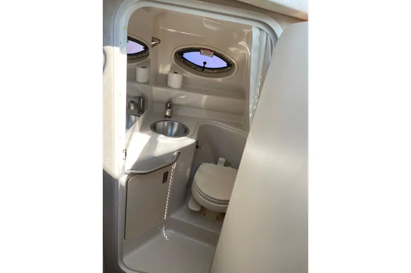 Slide: The Image of Interior of 2011 Sea Ray 240 Sundancer boat bathroom with sink and toilet. - 22