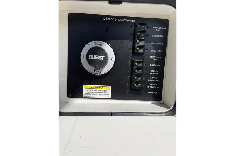 Slide: The Image of Main DC breaker panel on 2011 Sea Ray 240 Sundancer boat, featuring various switches and caution label. - 27