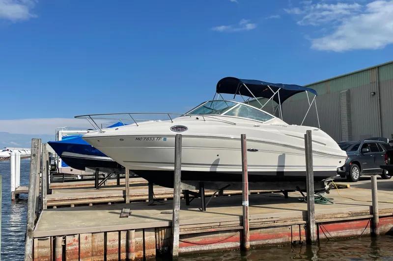 Slide: The Image of 2011 Sea Ray 240 Sundancer boat docked at marina under clear blue sky. - 3