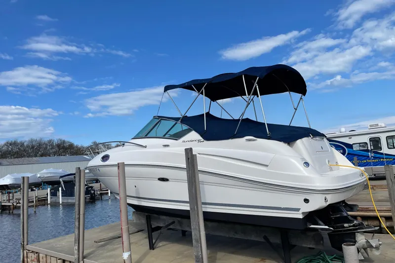 Slide: The Image of 2011 Sea Ray 240 Sundancer boat docked under a clear blue sky. - 4