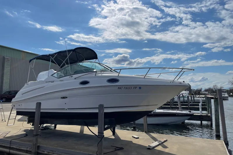 Slide: The Image of 2011 Sea Ray 240 Sundancer boat docked under a clear blue sky. - 6