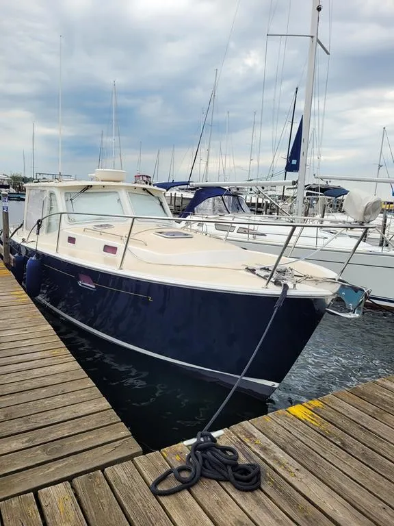 Slide: The Image of 2013 MJM 36z Downeast boat docked at marina under cloudy sky. - 4