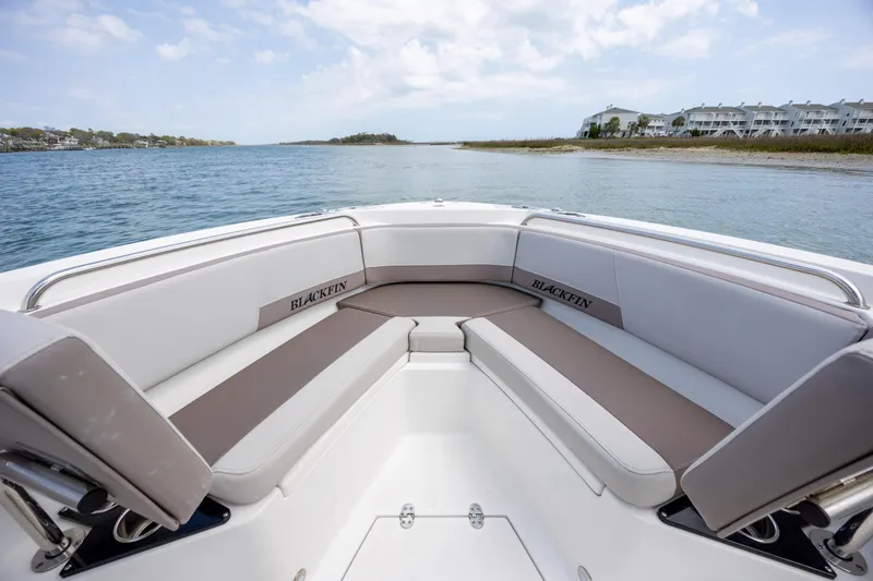 Slide: The Image of 2019 Blackfin 212 CC boat interior with cushioned seating, overlooking serene waters. - 10
