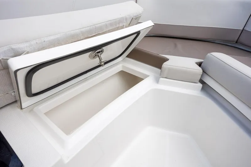 Slide: The Image of 2019 Blackfin 212 CC boat storage compartment with open lid and cushioned seating. - 12