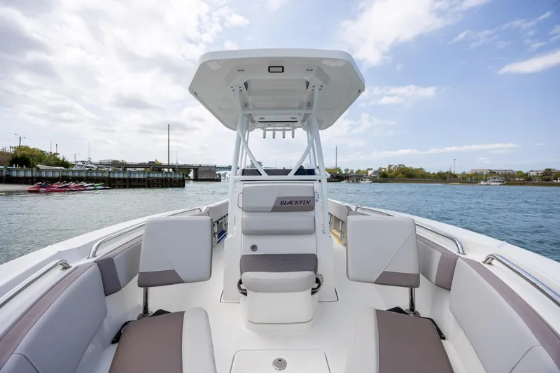 Slide: The Image of 2019 Blackfin 212 CC boat interior with seating, on calm water under a cloudy sky. - 15