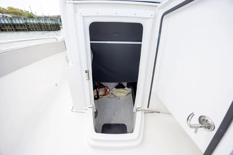 Slide: The Image of 2019 Blackfin 212 CC boat storage compartment with open door, dockside view. - 16