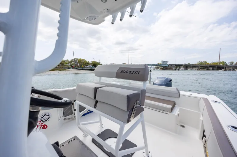 Slide: The Image of 2019 Blackfin 212 CC boat interior with seating, steering wheel, and water view. - 18