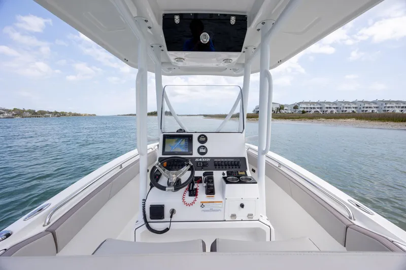 Slide: The Image of 2019 Blackfin 212 CC boat interior with steering console on calm water. - 19