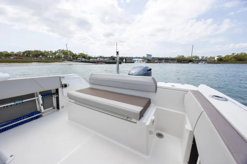 Slide: The Image of 2019 Blackfin 212 CC boat interior with seating, docked near a scenic waterfront. - 26