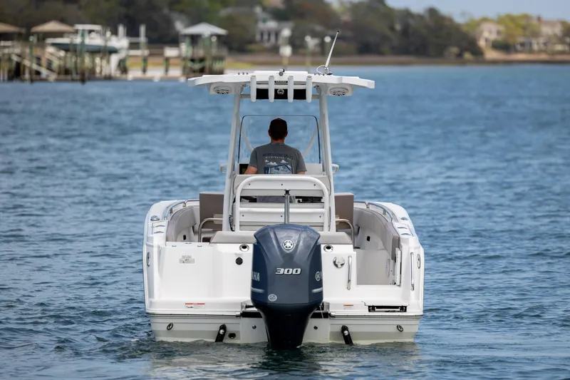 Slide: The Image of 2019 Blackfin 212 CC boat cruising on calm waters, rear view with outboard motor. - 6