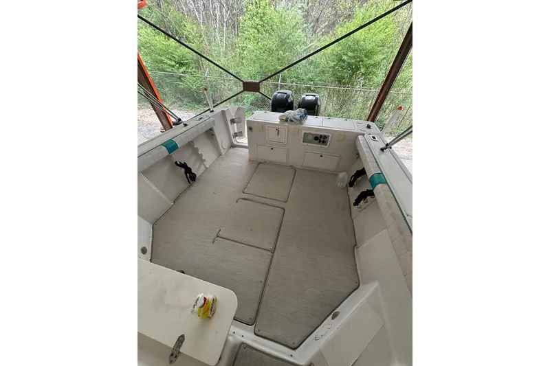 Slide: The Image of 1998 Pro-Line 2950 Walkaround boat interior with dual engines, under canopy. - 2