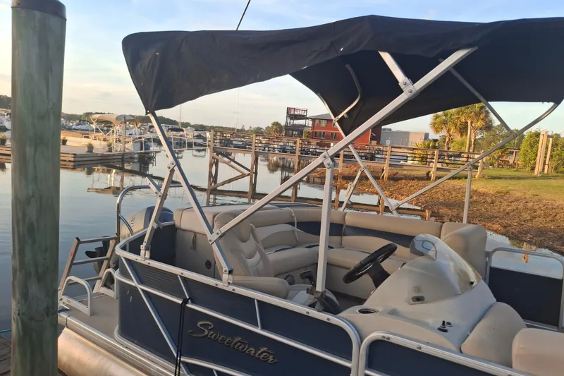 Slide: The Image of 2015 Godfrey Sweetwater 2286 C pontoon boat docked at a scenic marina. - 3