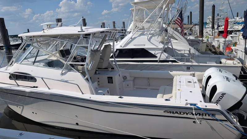 Slide: The Image of 2006 Grady-White Marlin 300 boat docked, featuring twin Honda outboard engines. - 1