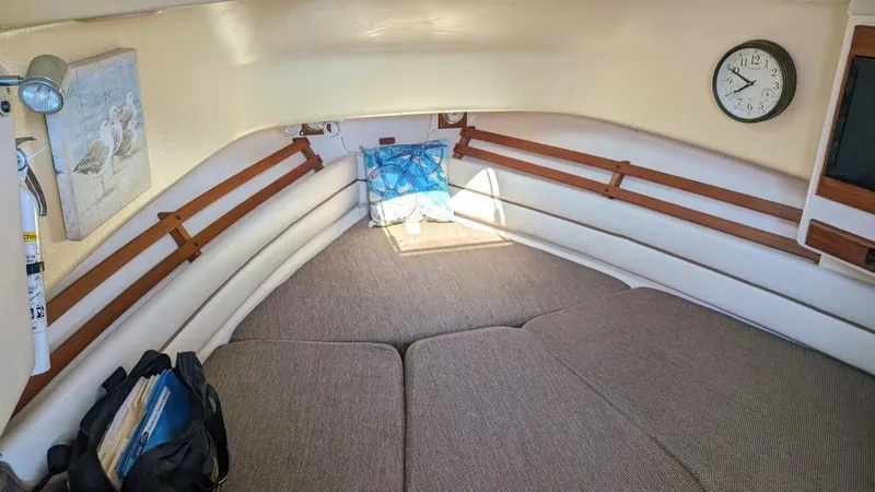 Slide: The Image of 2006 Grady-White Marlin 300 cabin interior with bed, clock, and wall art. - 11