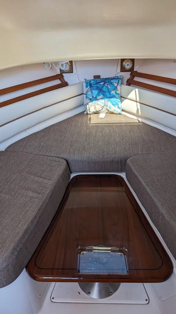 Slide: The Image of Interior cabin of 2006 Grady-White Marlin 300 with cushioned seating and wooden table. - 13