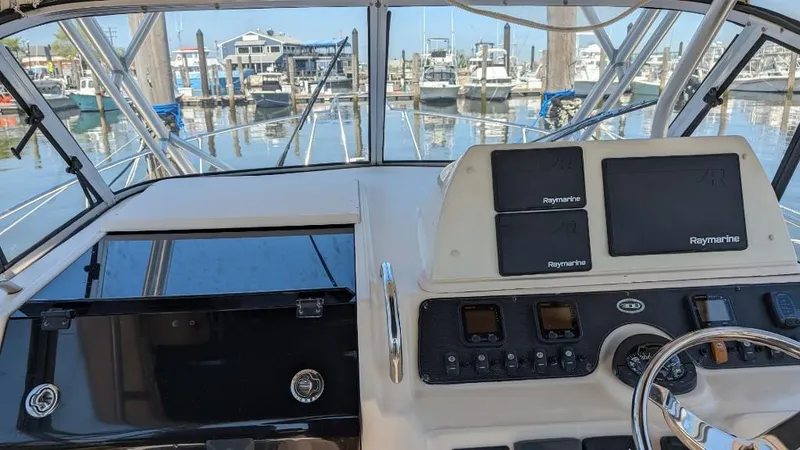 Slide: The Image of 2006 Grady-White Marlin 300 helm with Raymarine electronics at a marina. - 7
