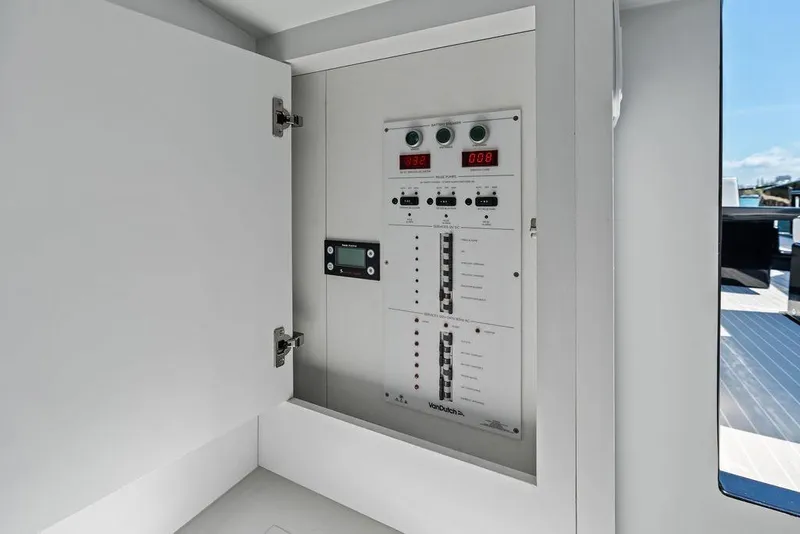 Slide: The Image of Electrical panel inside 2021 VanDutch 40.2 yacht, showcasing control switches and digital displays. - 17