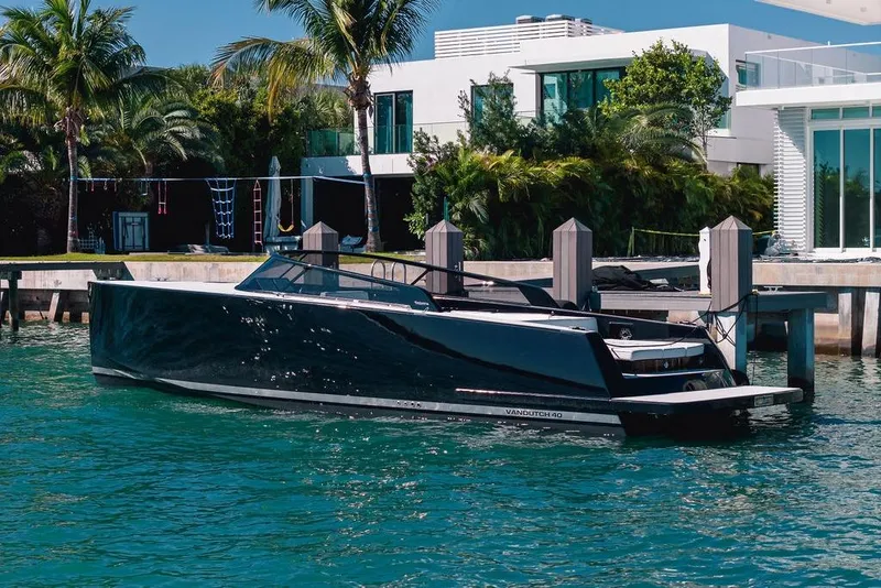 Slide: The Image of Luxury 2021 VanDutch 40.2 yacht docked by modern waterfront home. - 2