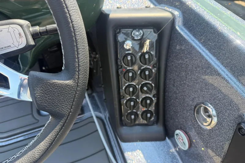 Slide: The Image of Dashboard controls of a 2026 Phoenix 721 ZXL boat, featuring switches and steering wheel. - 16