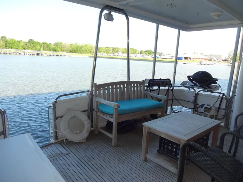 Slide: The Image of Deck of a 1996 President 545 boat with seating area and grill. - 12