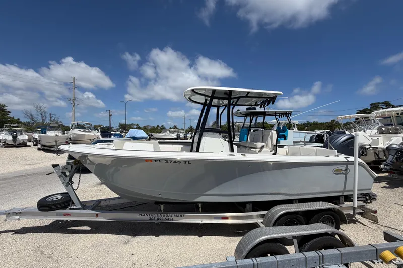 The Image of 2023 Sea Hunt Ultra 234 boat on trailer under clear blue sky. - 0