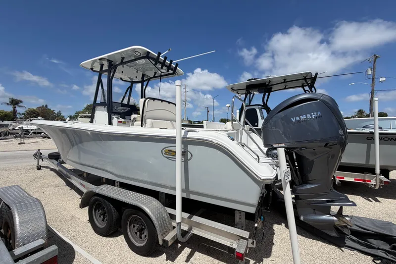 Slide: The Image of 2023 Sea Hunt Ultra 234 boat on trailer, featuring Yamaha outboard motor, under clear blue sky. - 1
