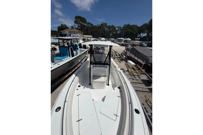 Slide: The Image of 2023 Sea Hunt Ultra 234 boat in a marina, surrounded by other vessels. - 15