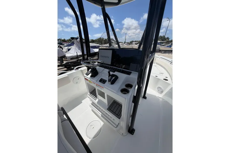 Slide: The Image of 2023 Sea Hunt Ultra 234 boat console with Garmin navigation system under clear blue sky. - 17
