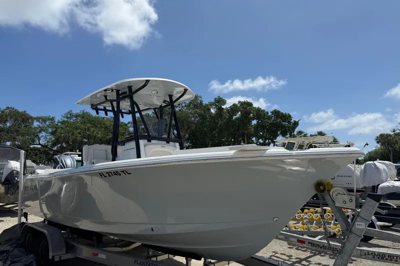 Slide: The Image of 2023 Sea Hunt Ultra 234 boat on trailer under clear blue sky. - 2