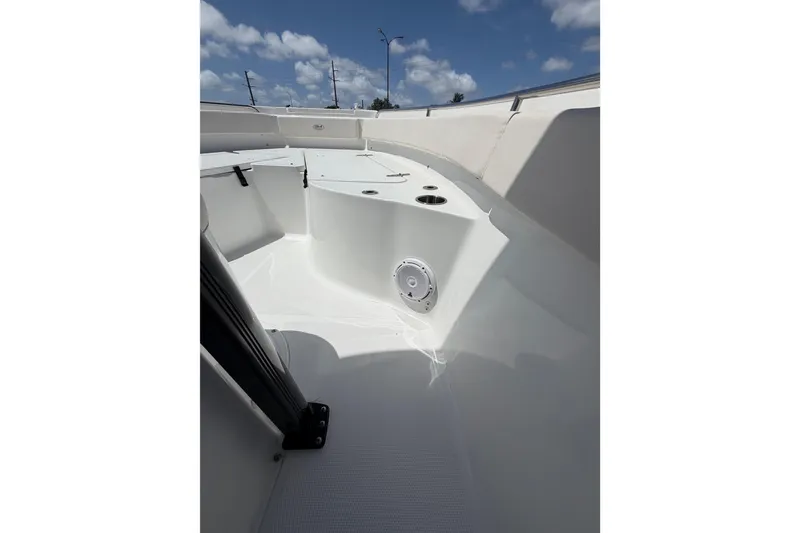 Slide: The Image of 2023 Sea Hunt Ultra 234 boat interior with seating and speaker, under blue sky. - 21