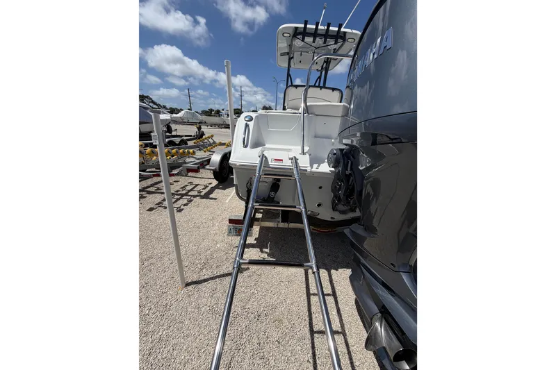 Slide: The Image of 2023 Sea Hunt Ultra 234 boat with ladder and Yamaha engine, parked on a trailer. - 24