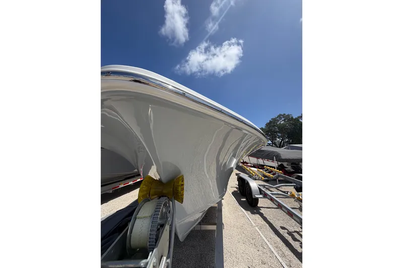 Slide: The Image of 2023 Sea Hunt Ultra 234 boat on trailer under clear blue sky. - 25